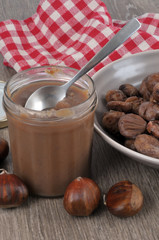 Pot de crème de marron à côté d'une assiette de marrons cuits