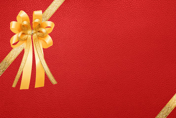 Golden ribbon with bow, on red leather paper texture, wrap gift box