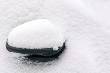 Car mirror covered with snow
