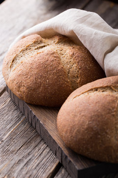 Wholemeal wheat bread on wooden background. Close up