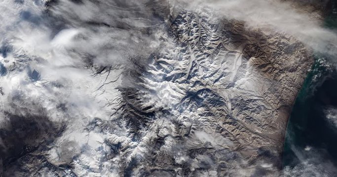 High-altitude overflight aerial of volcanic tundra, Kamchatka peninsula, Russia. Clip loops and is reversible. Elements of this image furnished by USGS/NASA Landsat