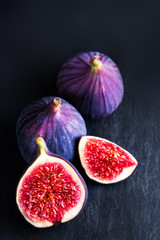 Fresh blue figs on black background. Beautiful violet figs with