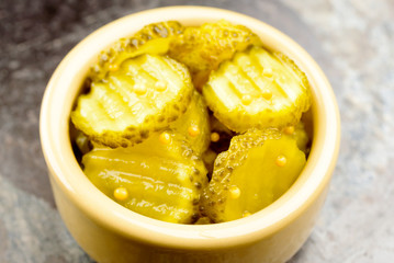 Fresh homemade pickled cucumber with mustard seeds in small ceramic bowl