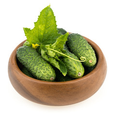 Tasty green cucumbers in wooden bowl, isolated on white