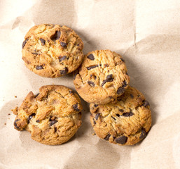 Chocolate cookies in brown paper, Chocolate chip cookies on wood