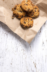 Chocolate cookies in brown paper, Chocolate chip cookies on wood