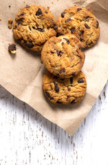 Chocolate cookies in brown paper, Chocolate chip cookies on wood