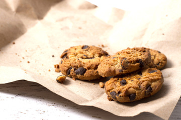 Chocolate cookies in brown paper, Chocolate chip cookies on wood