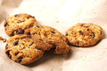 Chocolate cookies in brown paper, Chocolate chip cookies on wood
