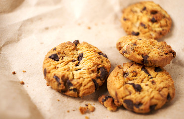 Chocolate cookies in brown paper, Chocolate chip cookies on wood