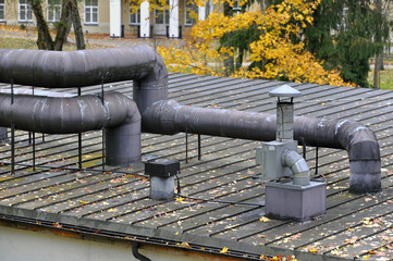 Seam roof with vent pipes and shafts in autumn.