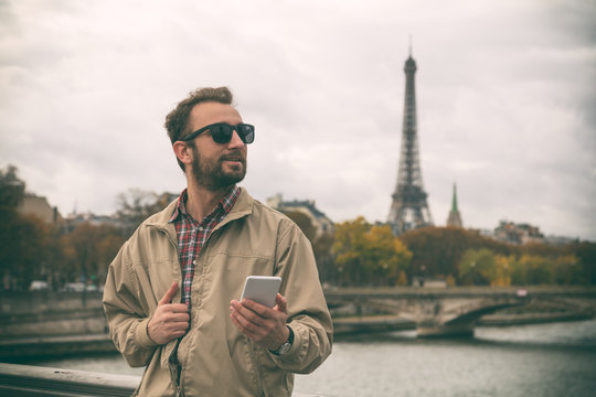 Modern guy using smartphone in the European city.