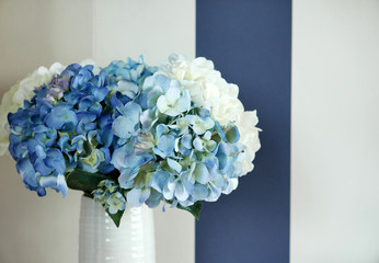 blue and white flower in white vase.