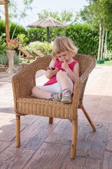 little girl watching mobile and picking nose