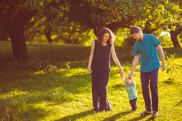Obraz premium The mother,father and son walking along park