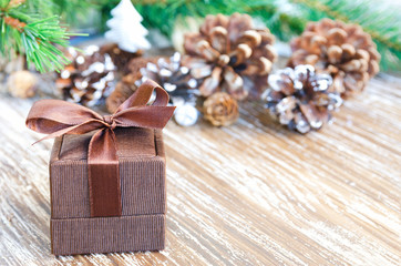 Naklejka na ściany i meble Vintage gift box with Christmas decoration: branch of fir, pine cones, tree ornament on wooden background. Merry Christmas o Happy New year concept. Copy space.