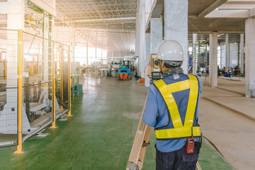 Surveyor engineer worker making measuring with theodolite equipment at construction site.