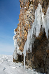 Fototapeta na wymiar Huge icicles on rocks. Beautiful winter landscape in Lake Baikal.