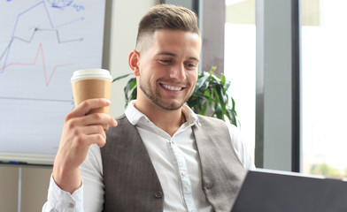 Modern businessman drinking coffee in the office during lunch time