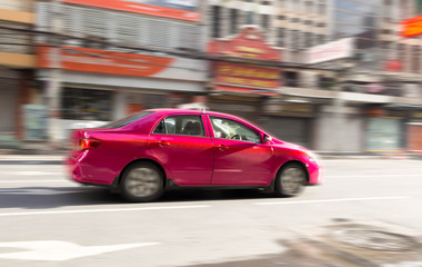 Blur motion concept of pink taxi on the road