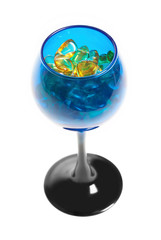 Yellow amber stones in the blue glass for wine.