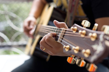 Man Practicing in playing acoustic guitar