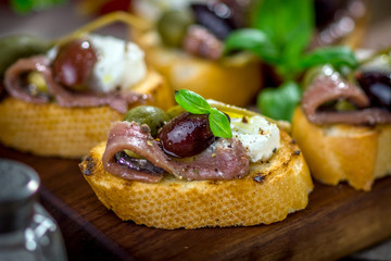Tasty bruschetta with anchovy, caper, olive oil ...
