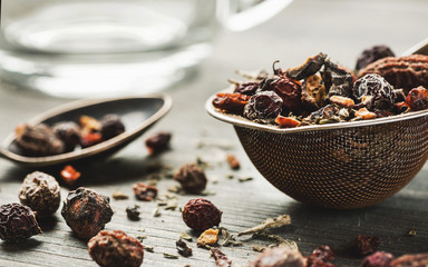 Herbal tea in metal stainer with silver spoon