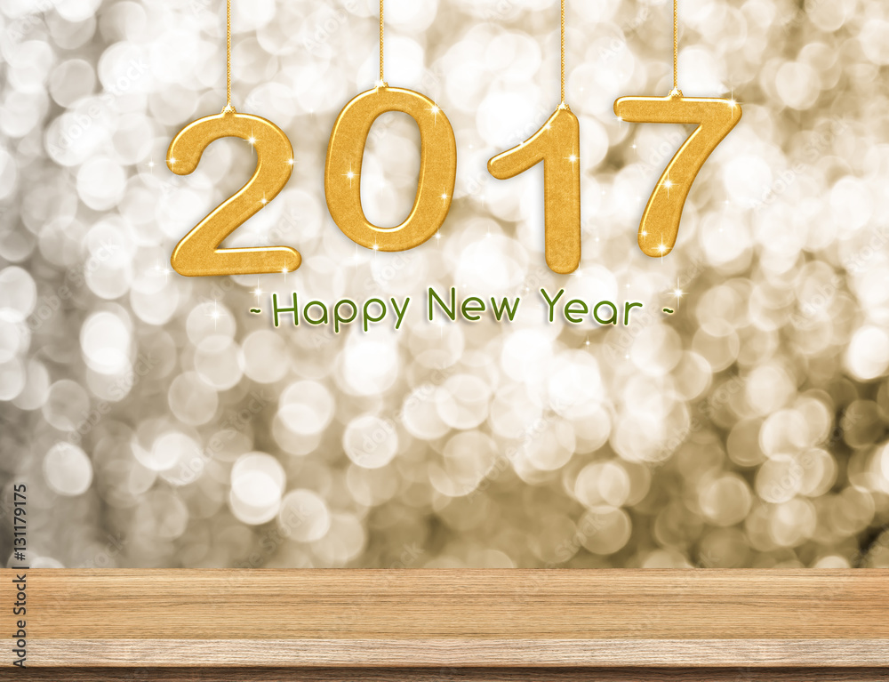 Poster 2017 new year hanging over plain wood table top with gold sparkl