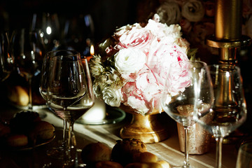Ray of light shines over pink bouquet of peonies which stands on