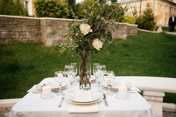 Dinner served for two outdoor, luxury lifestyle. Small table with plates and silverware sets