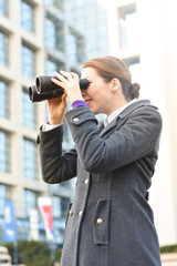 Fototapeta na wymiar Young business woman looking through binocular.