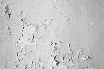 Black and White.  Natural background. Wall with a shabby and peeling paint and plaster. Contrast and volume, white, gray.