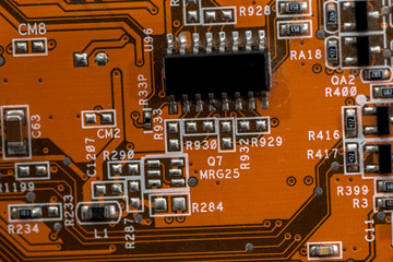 orange electronic circuit board close up.