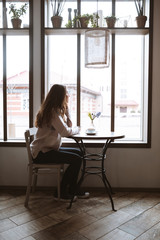 Pretty young lady sitting at cafe and waiting for boyfriend