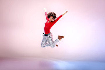 Naklejka na ściany i meble Young girl dancing, jumping.