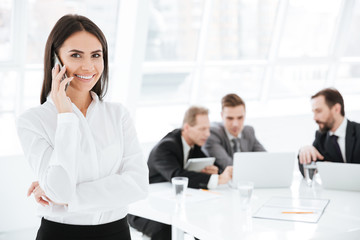 Attractive Business woman with colleagues on background