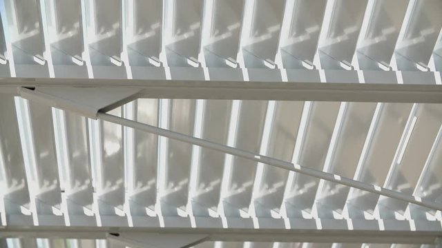 A sun shading system is closing down and preventing too much light to come in and so ensuring passive cooling and quality daylight within the building.
