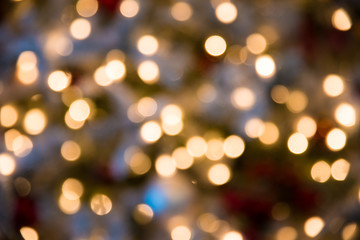 Festive New-year background with bokeh from Christmas tree lights glowing. Blurred colorful circles on light holiday 