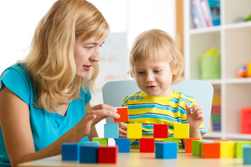 Child together with mother playing educational toys