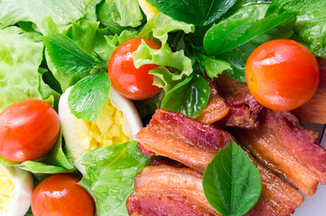 Detail of a plate with cherry tomatoes and bacon