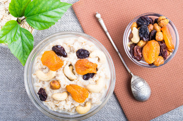 Top view of oatmeal porridge with raisins, cashews and dried apr