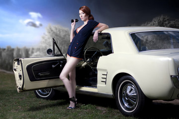 Frau in Pin up retro / Vintage Fashion  posiert an einem US Classic Car Oldtimer