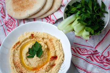 Home classic hummus with celery, pita. View top on gray concrete background. Vegan Food Concept.