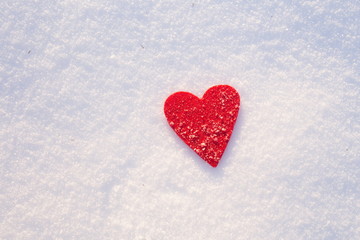 Red felt heart shape in snow, Valentine's Day. Copy space for text. Snowflakes on heart. Valentines day, love concept. White background