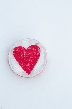 Red felt heart shape in a bowl in snow, Valentine's Day. Copy space for text. Snowflakes on heart. Valentines day, love concept. White background