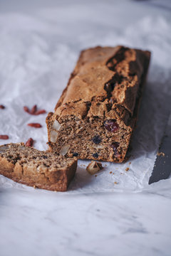 Loaf of healthy vegan fruit bread on white marble table