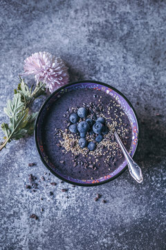 Blueberry acai banana smoothie bowl with blueberries, sesame seeds and cacao nibs
