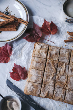 Baked blondies cake sprinkled with cinnamon sugar on a white mar
