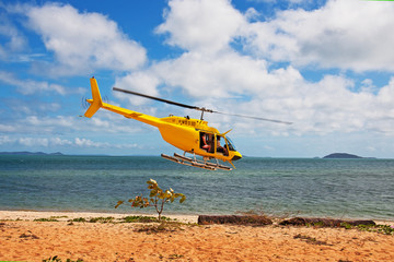 helicopter flies over the beach © Natalie